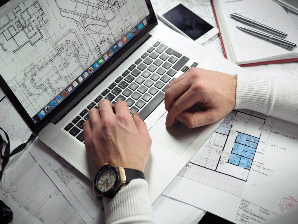 A photo of a faceless architect working on an architecture map on his laptop. Being an architect is one of the highest-paying jobs in Winnipeg.