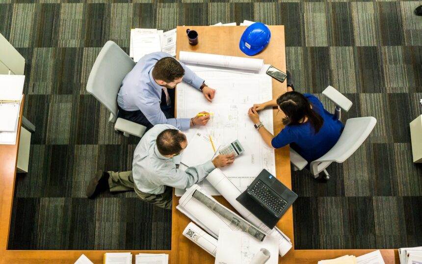A group of professionals working together on a table.