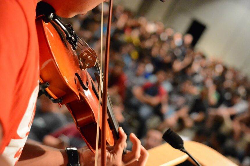 A close-up of a violin performed and played by a person in front of the audience. Fever is organizing Candlelight's Tribute to Fleetwood Mac in Calgary.