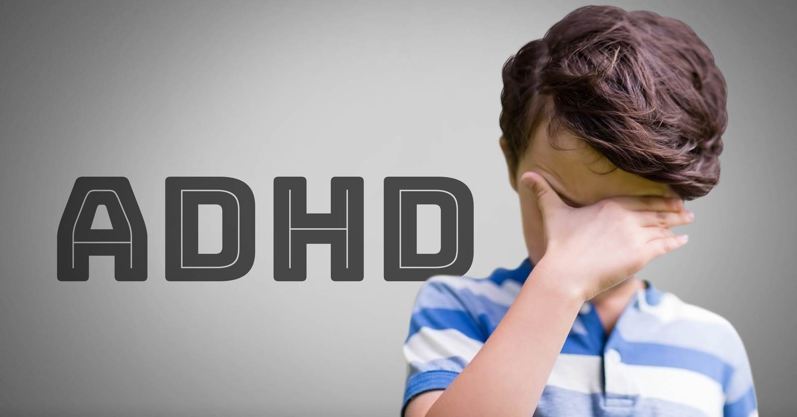 A child, with ADHD, is distressed and keeps his hand on his eyes and forehead. 