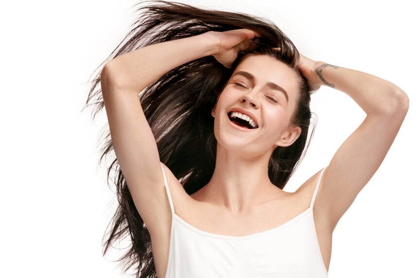 A happy woman waving her hair in the air.