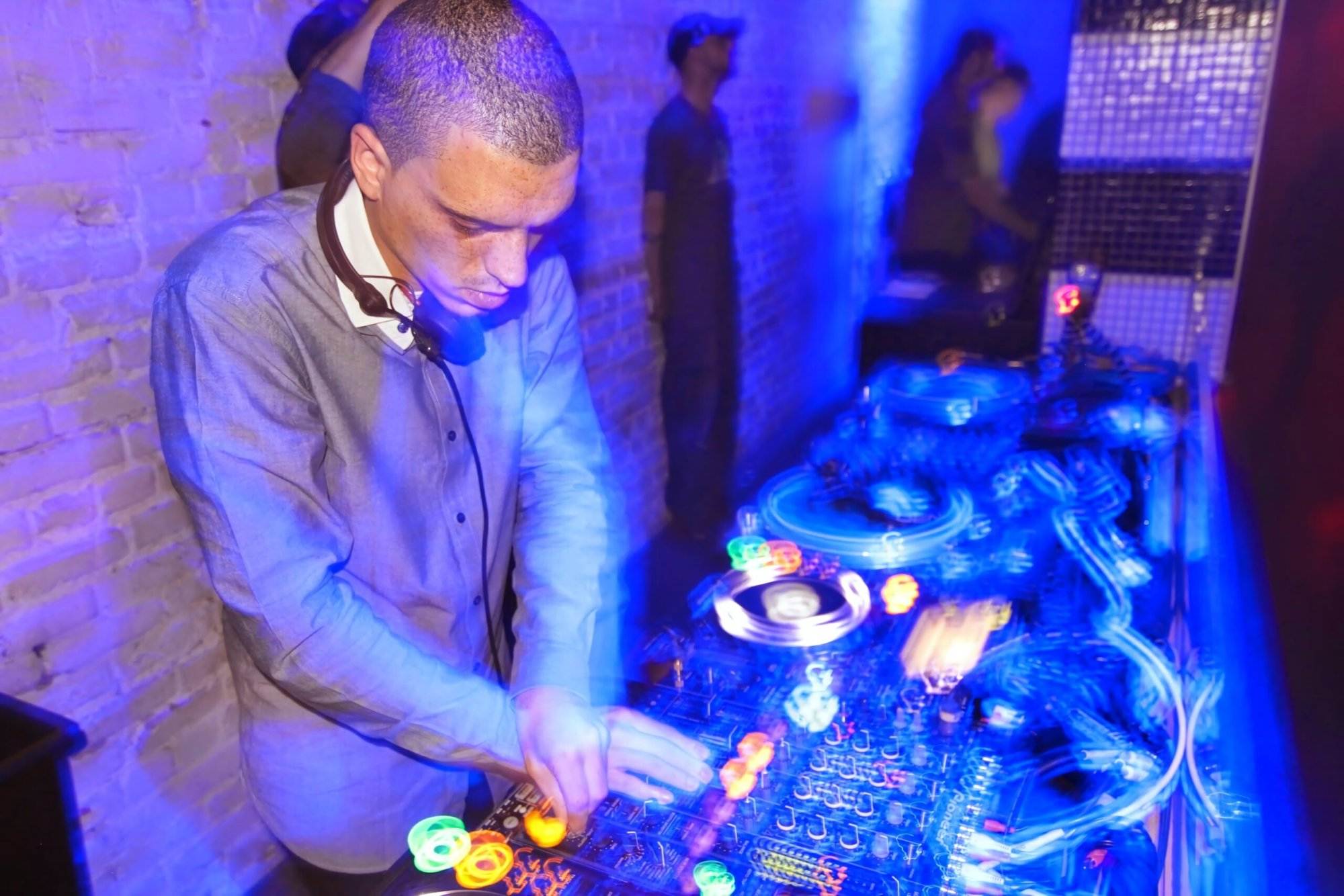 A DJ playing music with neon lights around in one of the Vancouver nightclubs.