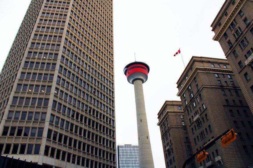 A low-angle shot of Calgary Tower among the high-rise buildings.