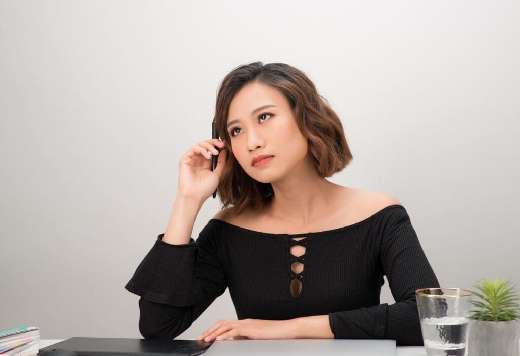 A woman with short hair and wearing a black outfit thinking while looking in the upward direction.