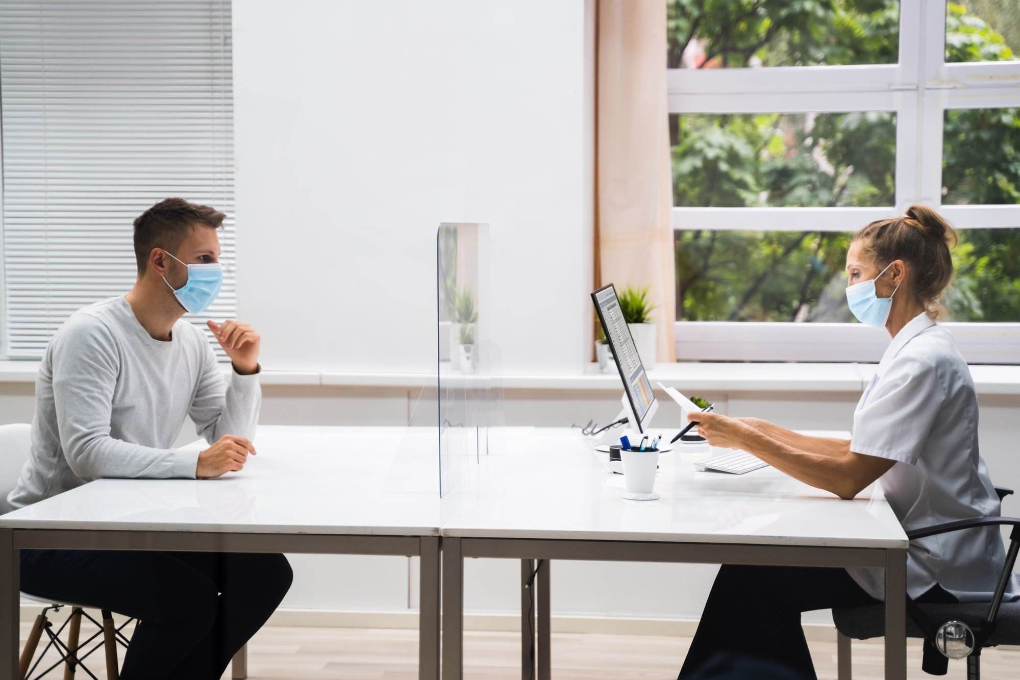 A view of a Health care Consultants meeting with the person who needs consultation in a hospital room.