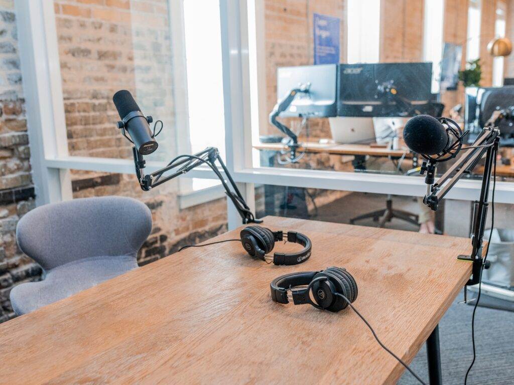 An empty recording room with mics and headphones kept on the table to record a podcast.