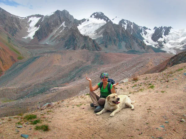A woman sitting beside her dog while hiking in banff national park