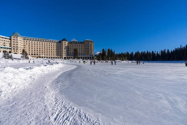  Tourists skating on the Fairmont Chateau Lake Louise winter ice skating rink.