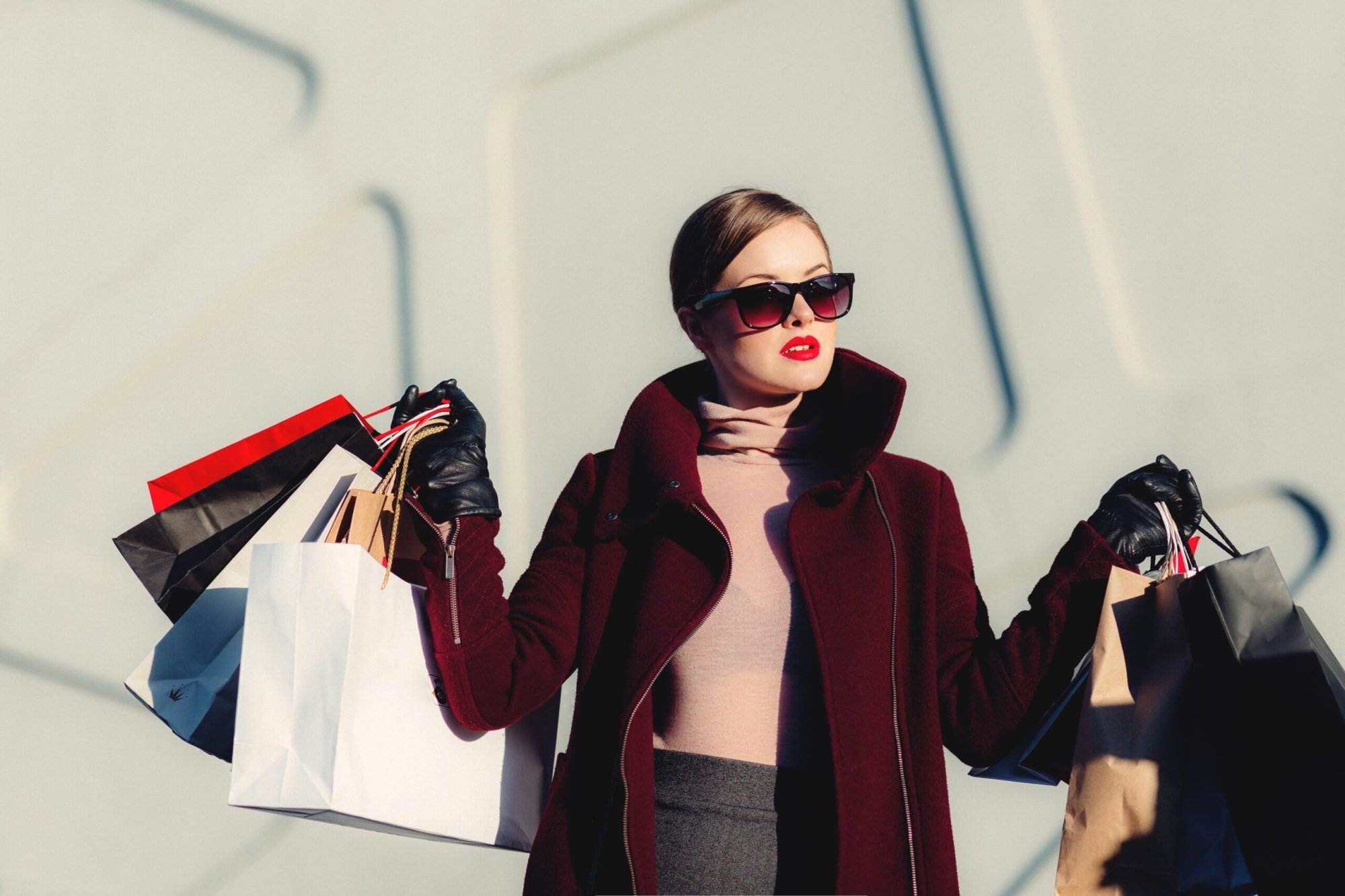 A woman happily holding shopping bags after shopping from the renowned outlet.