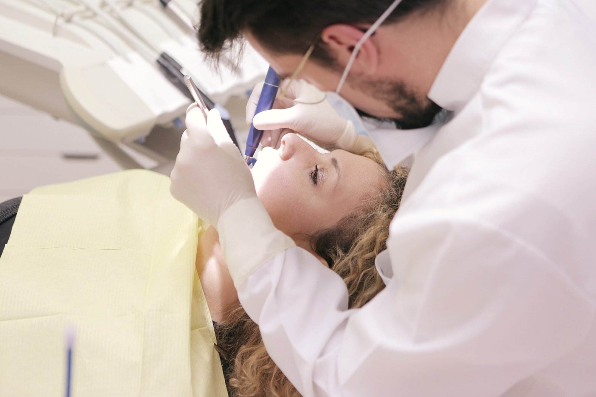 A view of a dentist curing the teeth of his patient.