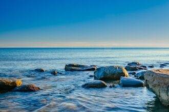 A view of rocks in the lake during the evening time.