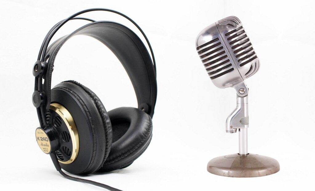 A view of headphones and a mic on a plain white background.