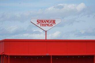A sign board of the Stranger Things logo on the top of a building.