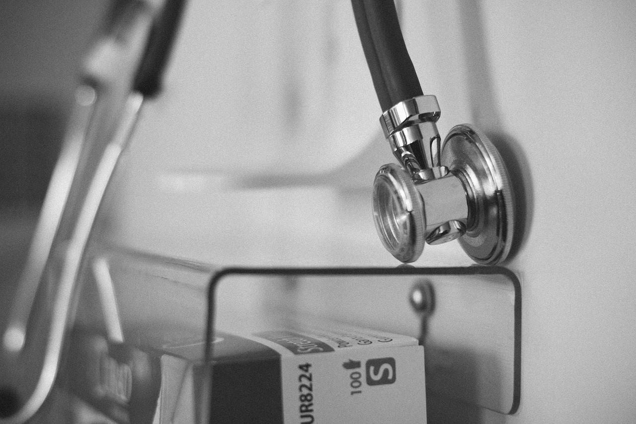 A black-and-white image of a stethoscope hanging.