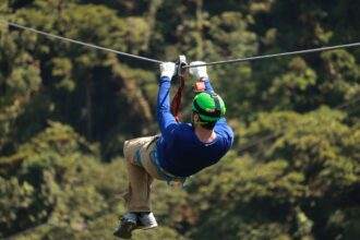 A man with a blue t-shirt during a zip-line experience.
