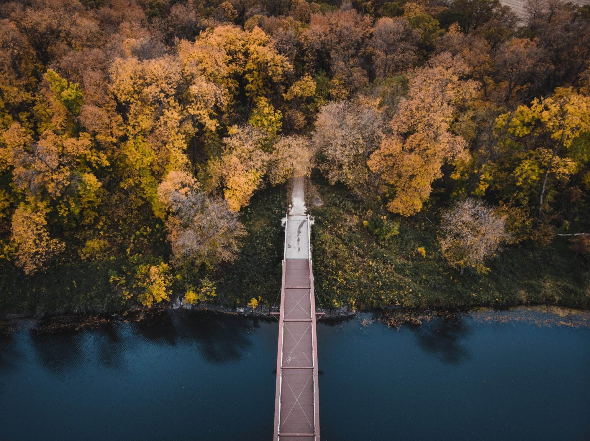 Dark and moody photo of a bridge and a river in Fall