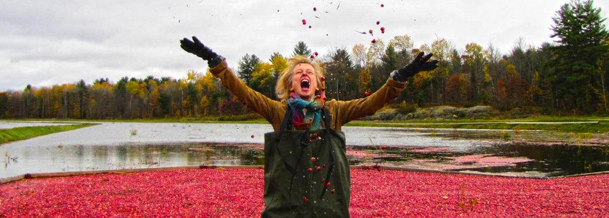 A woman playing with cranberry in the heart-shaped layer on the waterbody at the Muskoka Lakes Farm