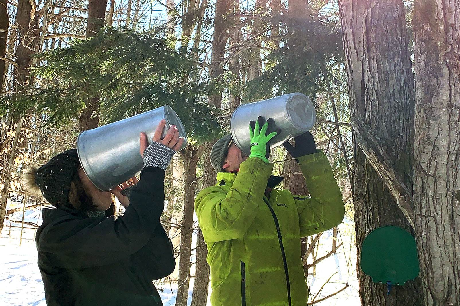 Two people drinking from two huge glasses.