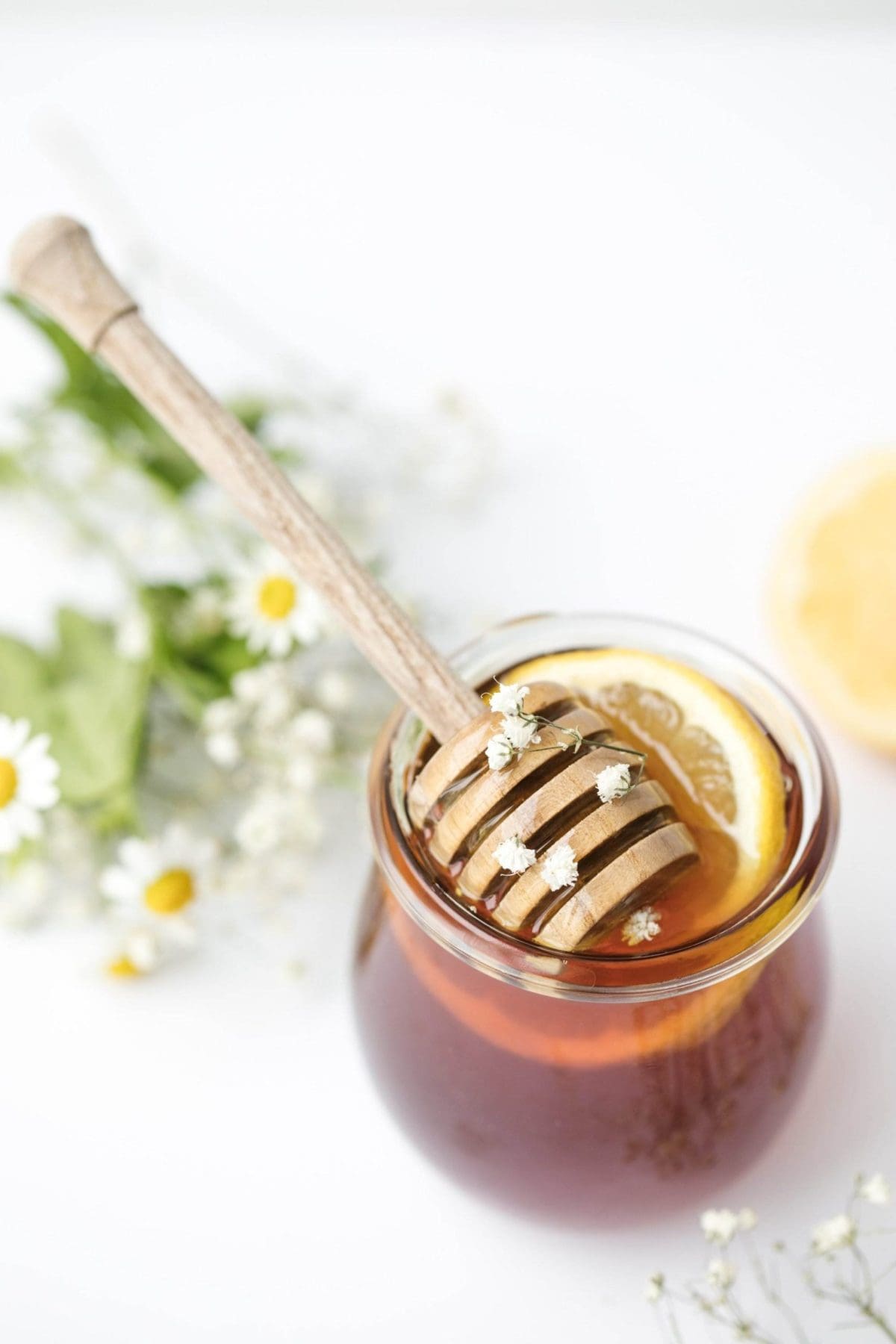 A jar of honey with the dipper in it.