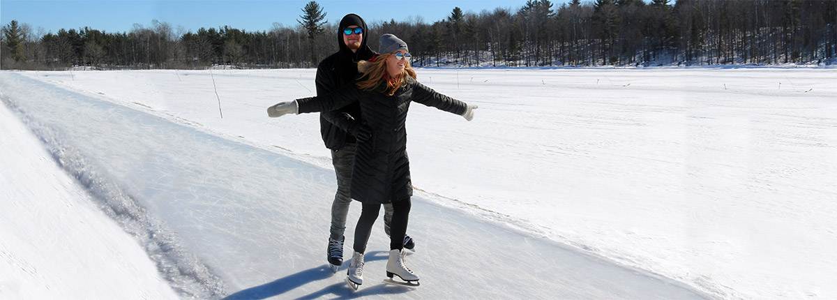 A couple snow skating on a snow path. 