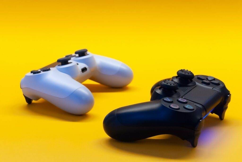 Two game controllers in the plain yellow background