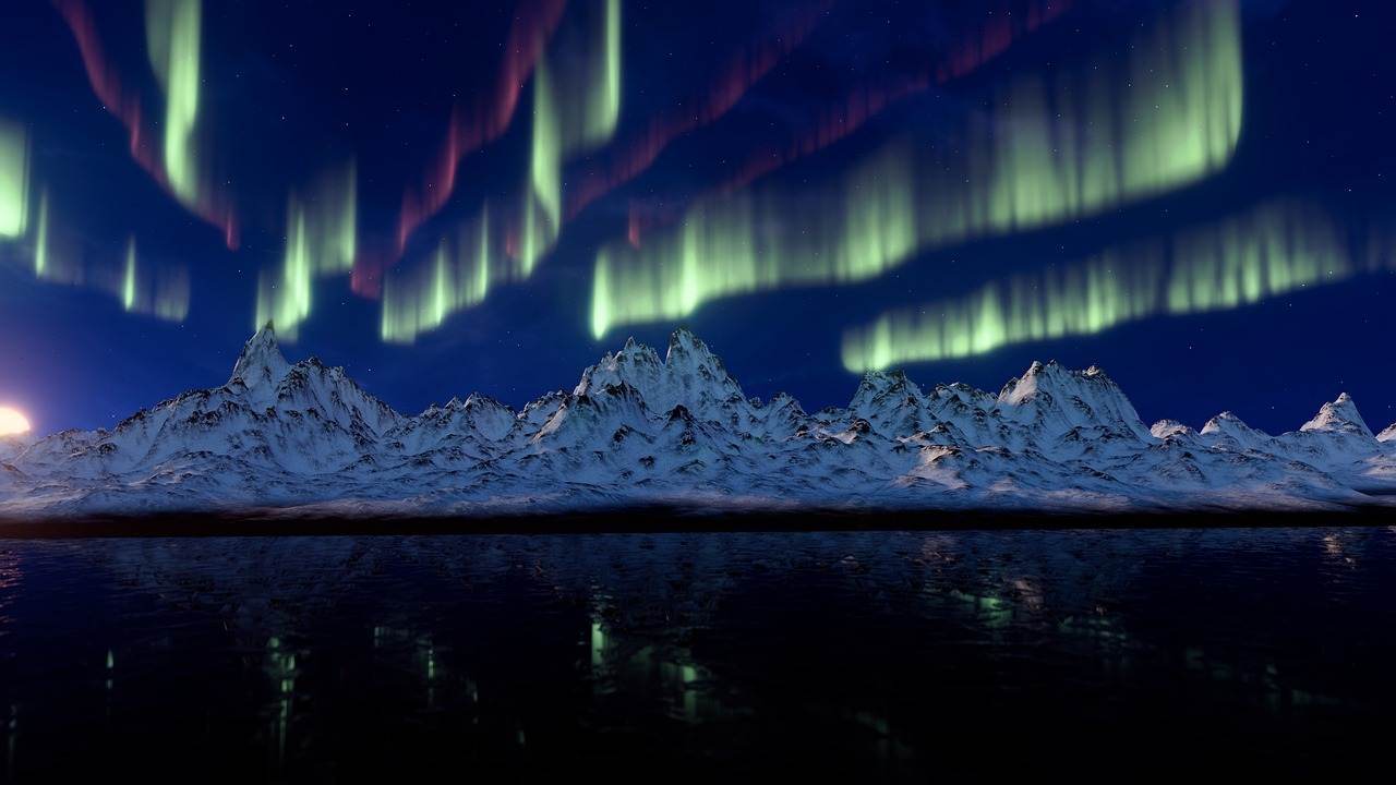 Northern lights in Canada over a waterbody and mountains.