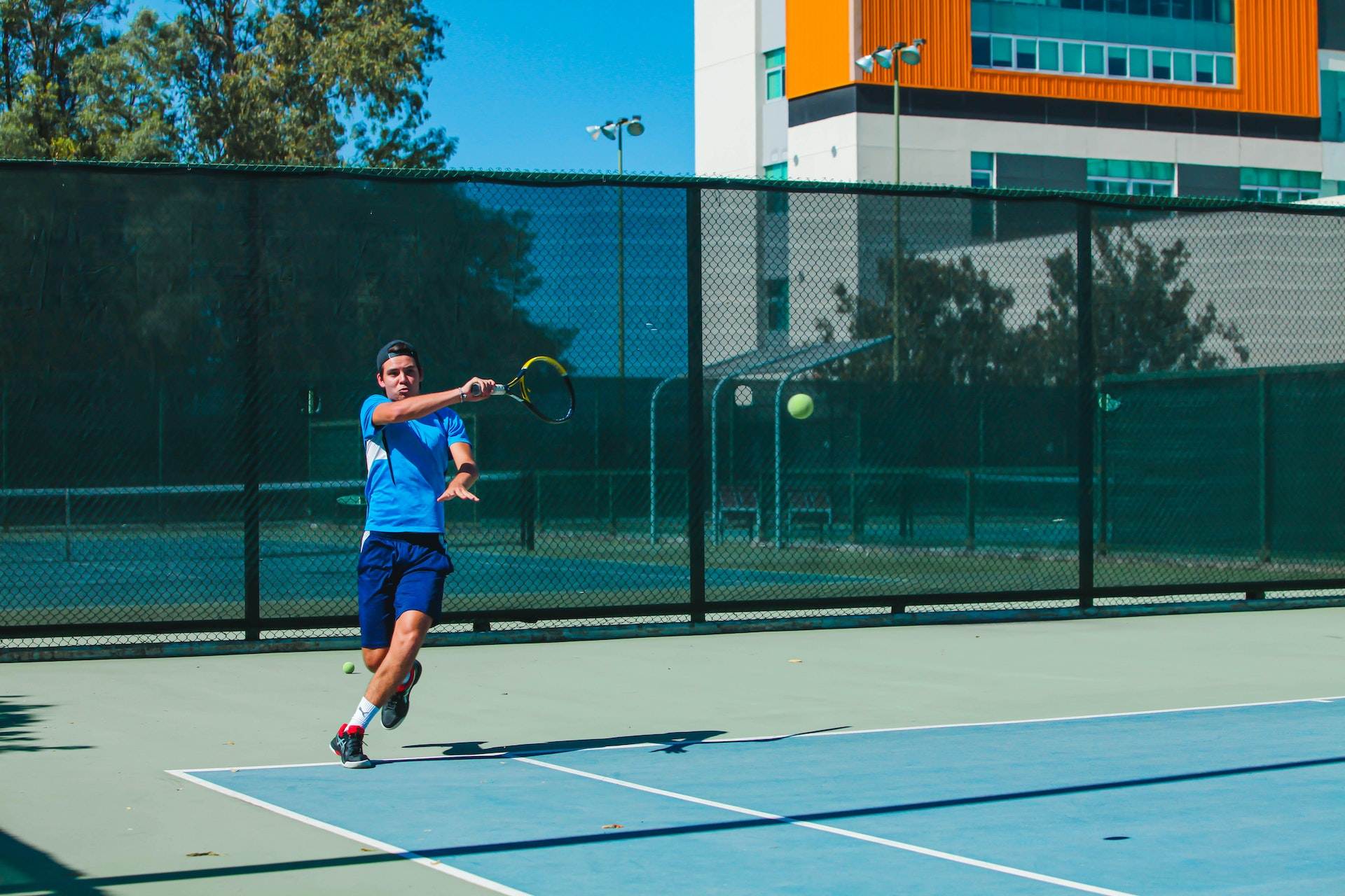 A person playing tennis on a tennis lawn.