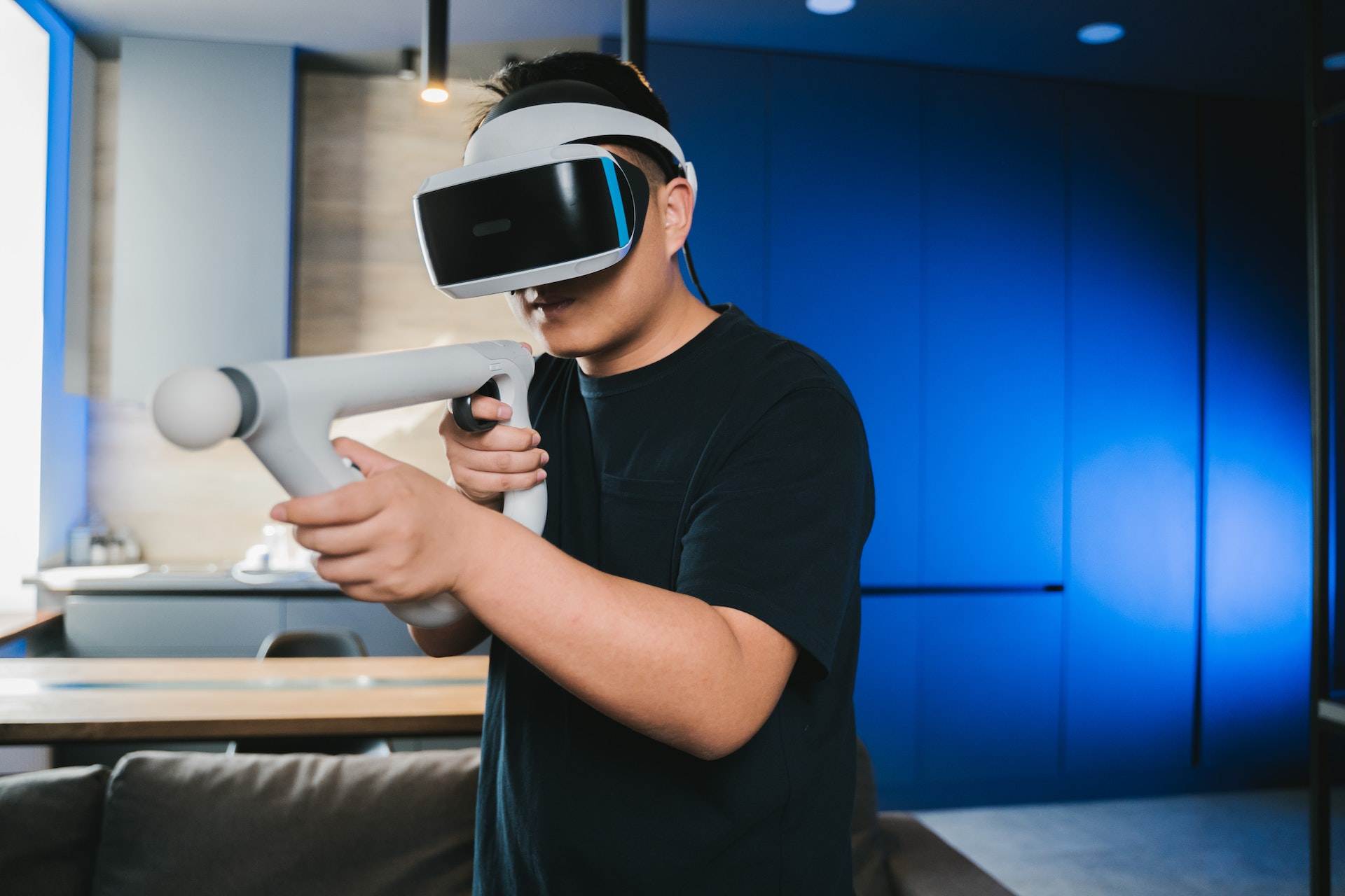 A man wearing a VR headset and a play-gun for the VR game experience.
