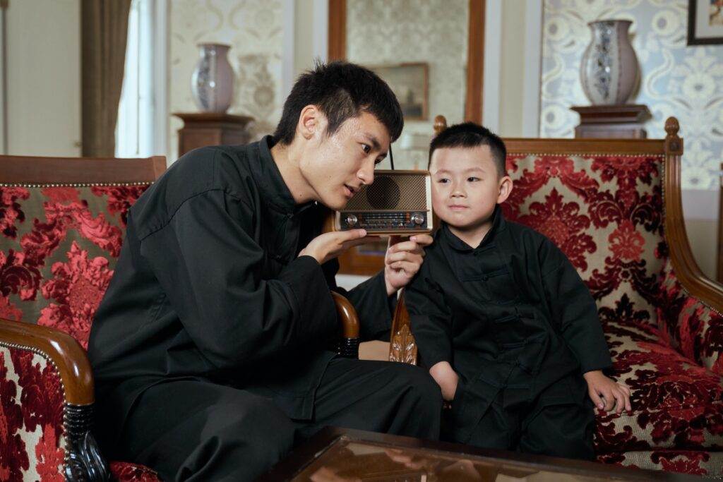 A man and a child listening to a radio.