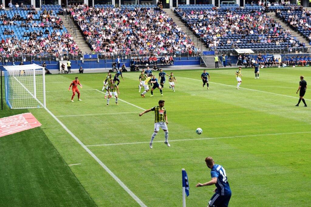 Men playing soccer on field during daytime