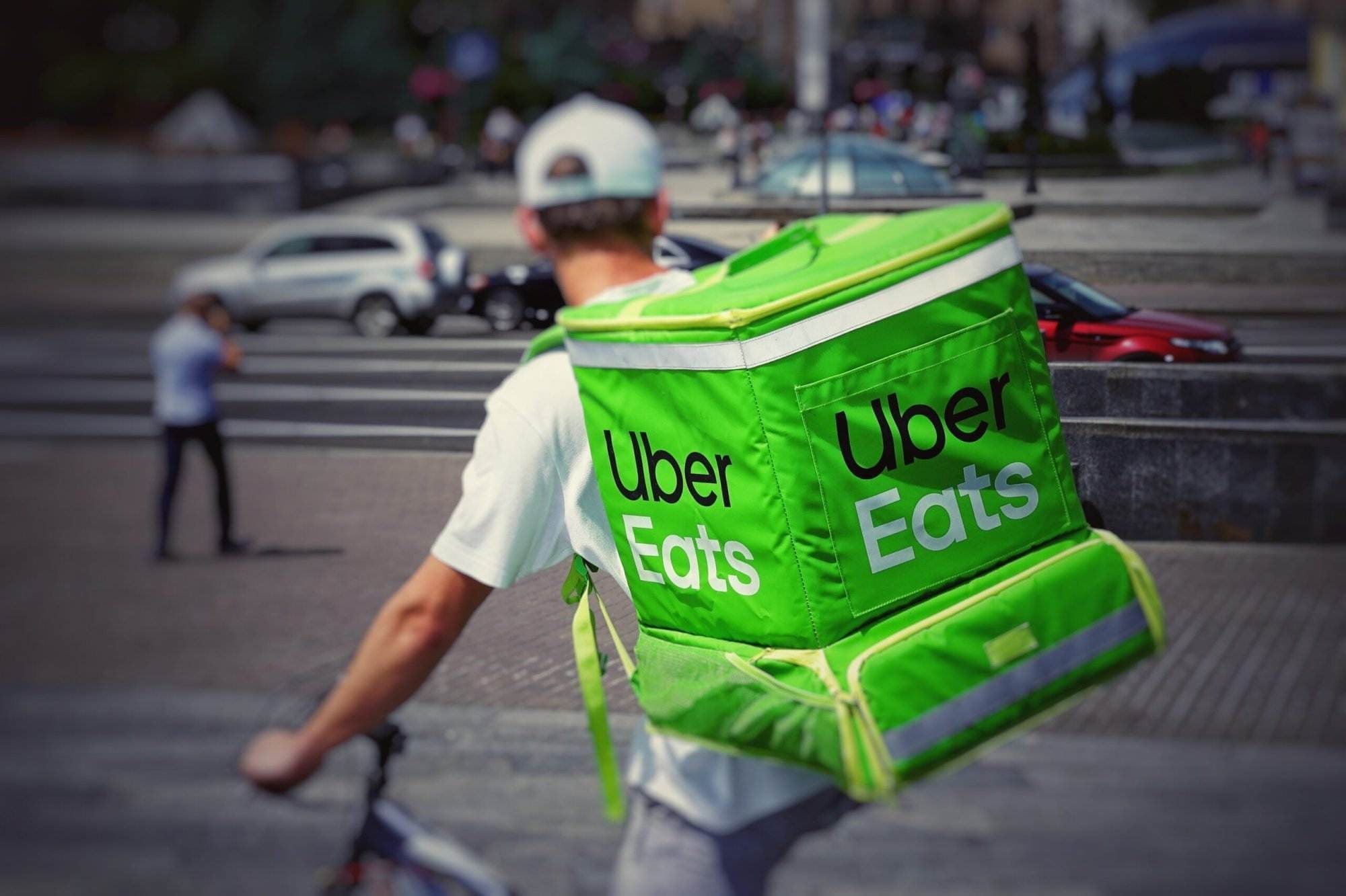 A person hanging the Uber Eats bag on his back to deliver food.