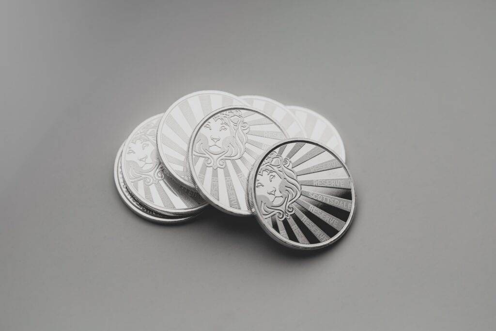 Some silver coins lying on a plain surface.