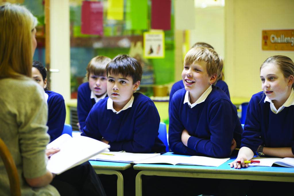 Children studying a class with the help of a tutor.