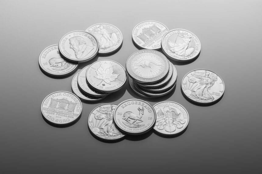 Silver coins are scattered on a plain background.