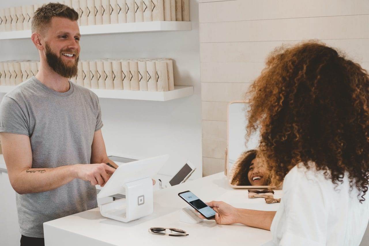 man smiling to woman on counter.