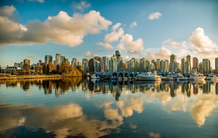 A scenic view of Vancouver with the high-rise buildings and a waterbody alongside.