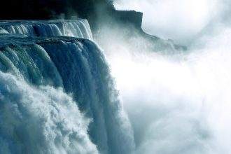 A view of Niagara falls where water falls with force.