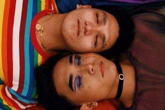 A homosexual male couple lying together.