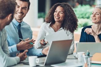 Professional team laughing during a friendly business meeting.