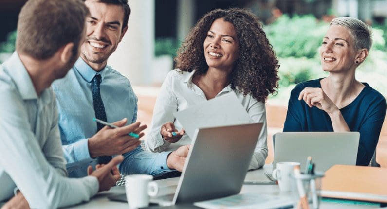 Professional team laughing during a friendly business meeting.