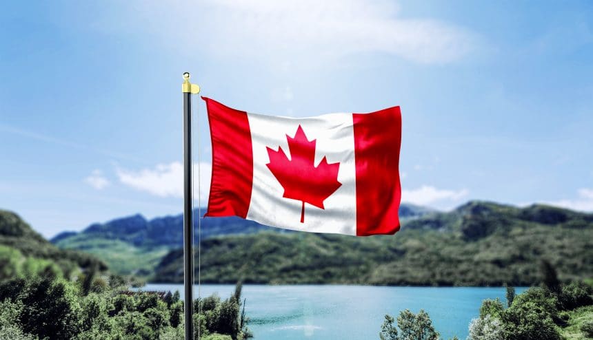Canadian flag waving with mountain and lake scenery.