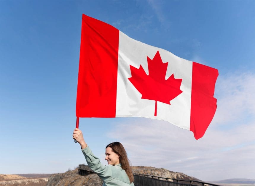Woman waving Canadian flag outdoors against clear sky
