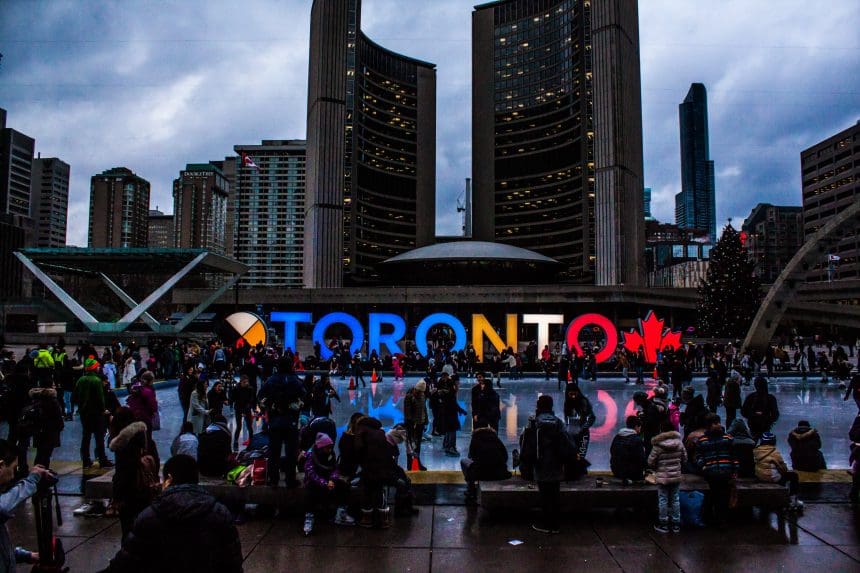 Crowd at Toronto city sign during dusk.