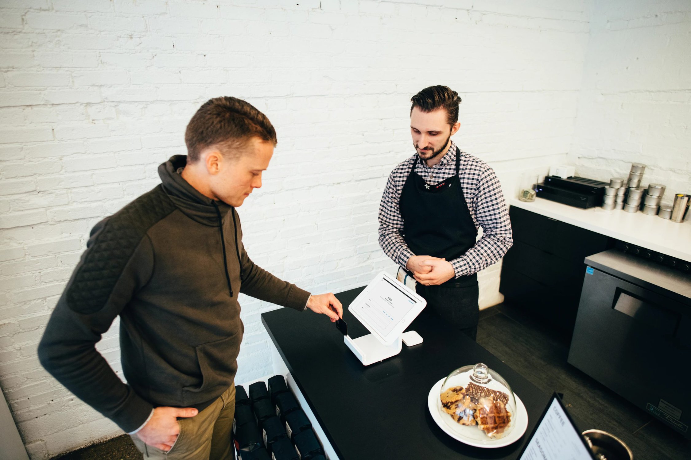 Man looking at white digital device.