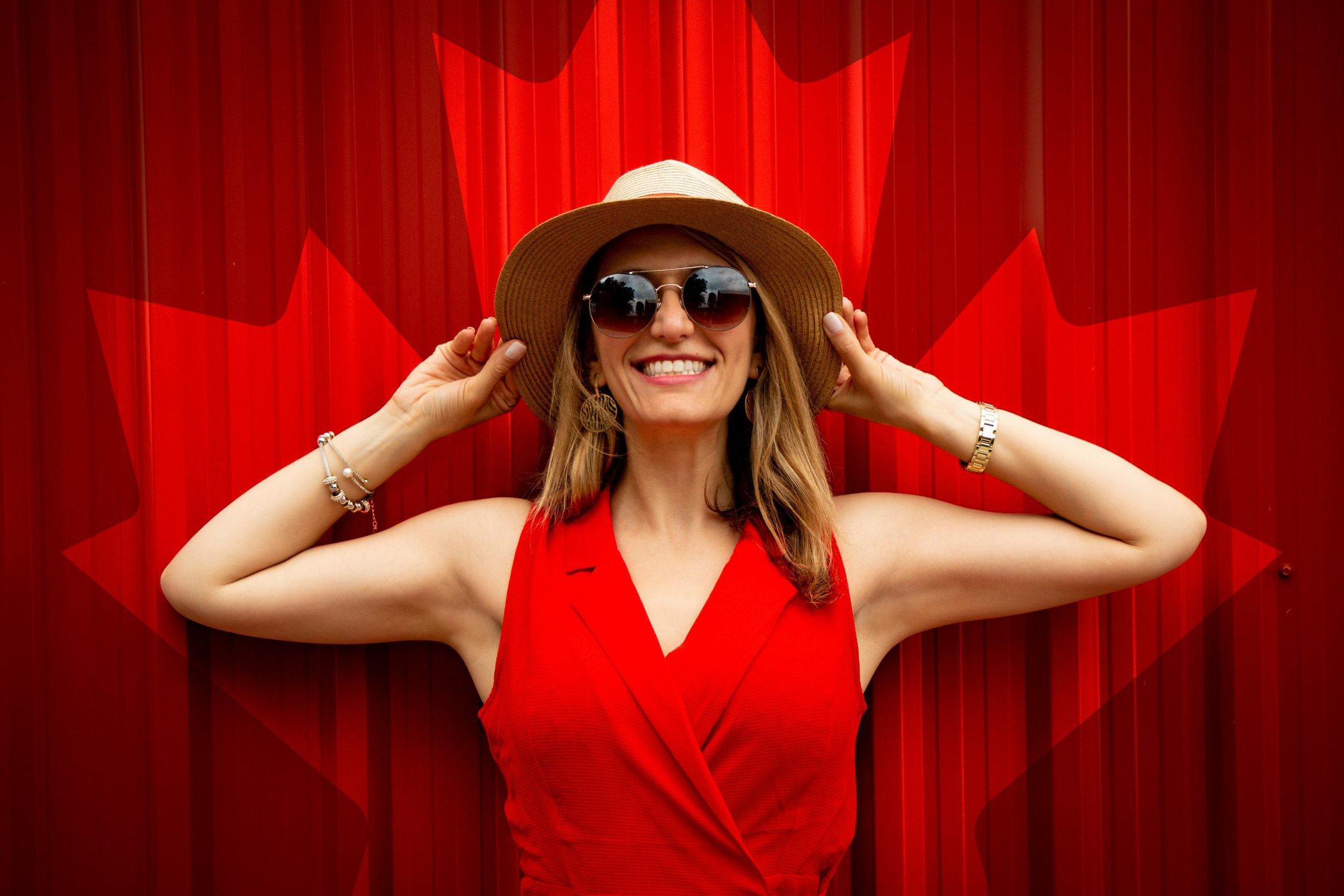 A Canada Print Behind a happy woman in Red 
