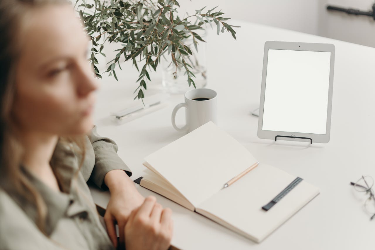 Girl sitting with tab and dairy.
